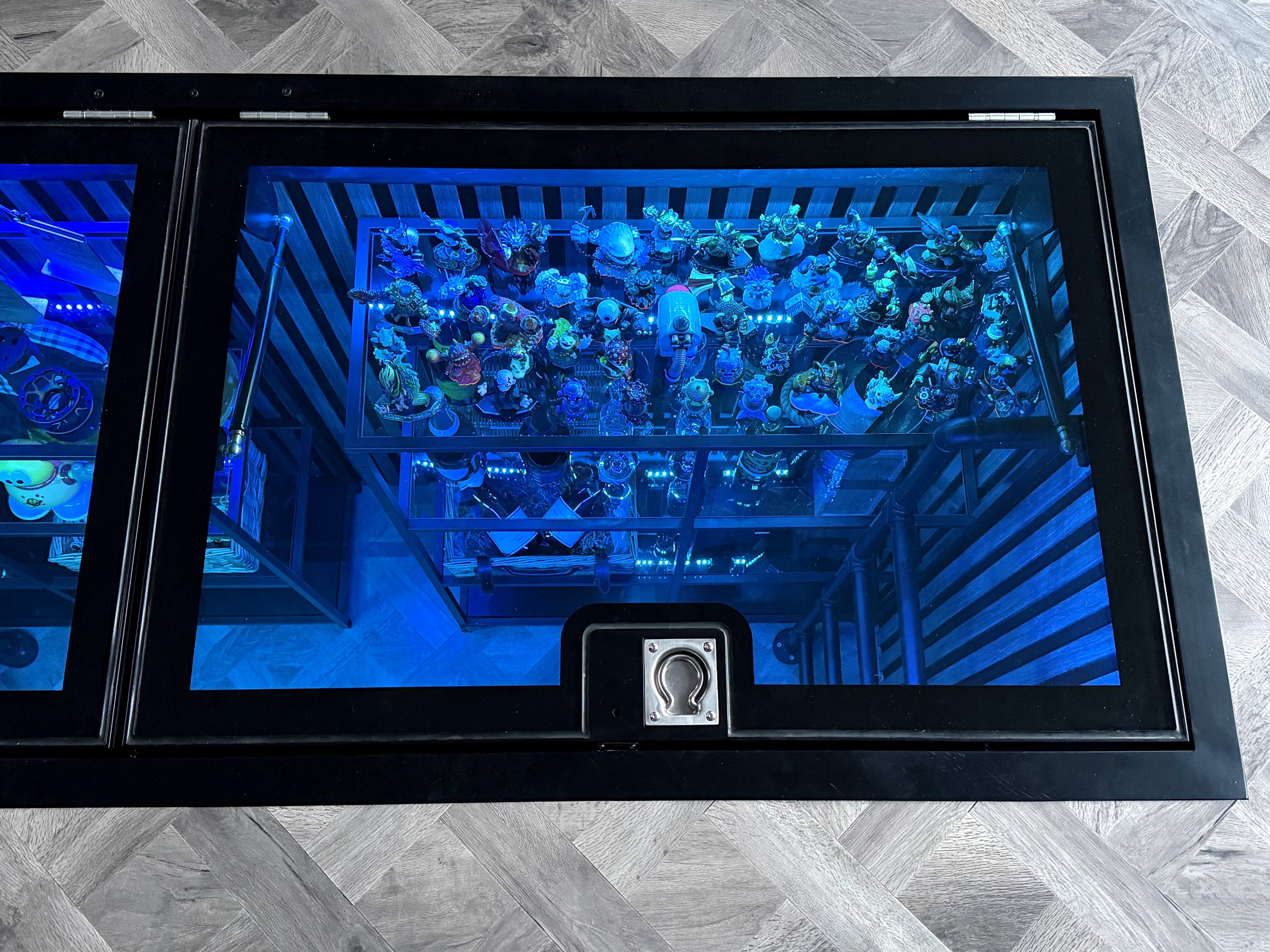 Champagne, glasses and collectibles displayed on shelving in converted inspection pit beneath hinged glass floor, Ashbourne Derbyshire